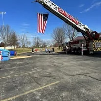 A fire truck with an American flag raised over the parking lot