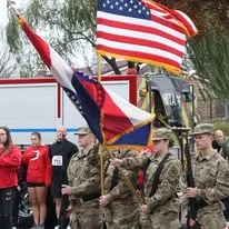 Color guard members holding flags and rifles