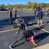 Participants doing bear crawl exercises at a battle station